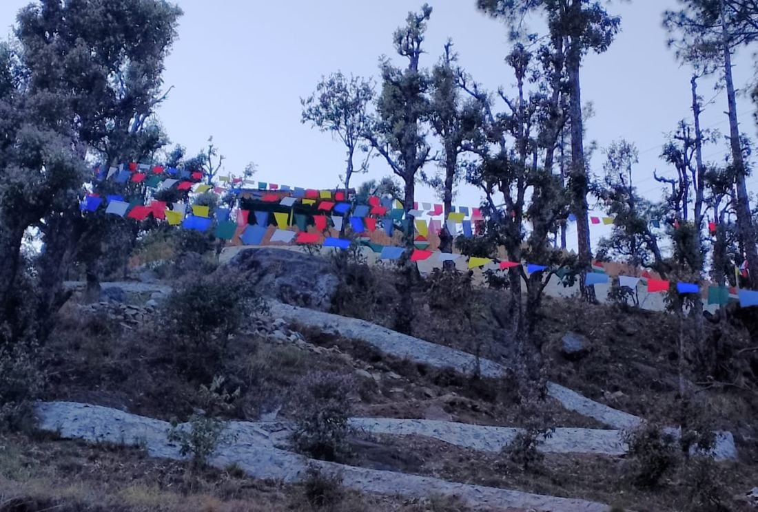Prayer flags above the hillside path to the homestay